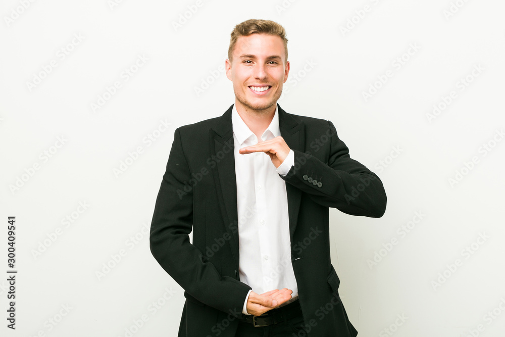 Young caucasian business man holding something with both hands, product presentation. Young caucasian business man holding something with both hands, product presentation.