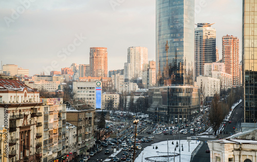 Downtown of the big city in the winter. On the streets of metropolis there are old houses  modern high-rise buildings  business centers. The roads are filled with cars  hard traffic