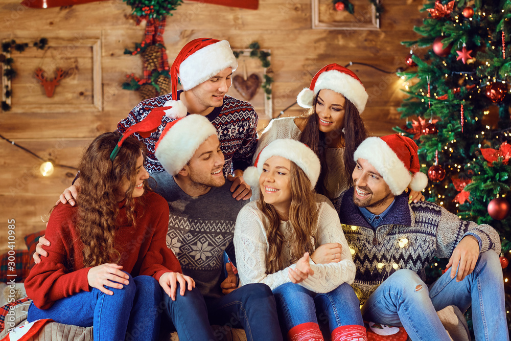 Group of laughing friends in Santa hats Group of laughing friends in Santa hats