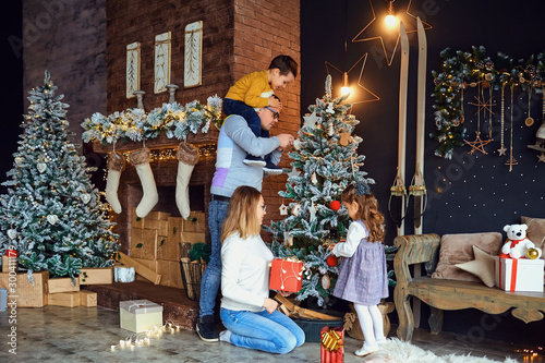 Parents and kids decorating Christmas tree © Studio Romantic