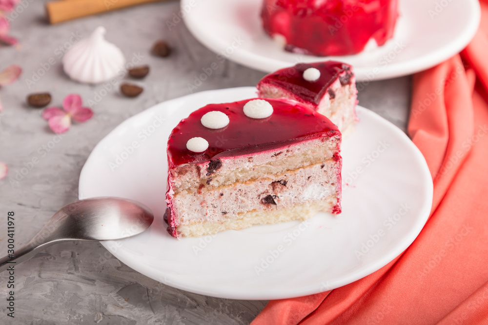 Sliced red cake with souffle cream with cup of coffee on a gray concrete background. side view, selective focus. Sliced red cake with souffle cream with cup of coffee on a gray concrete background. side view, selective focus.