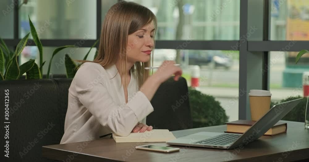 Businesswoman relaxing with book in cafe indoors in the day. Female in work time. Dolly shot Businesswoman relaxing with book in cafe indoors in the day. Female in work time. Dolly shot