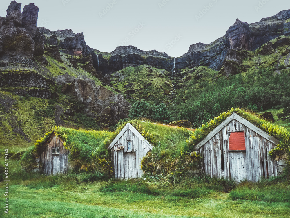 Row of grass covered wooden houses in Nupstadur in Iceland with moody weather