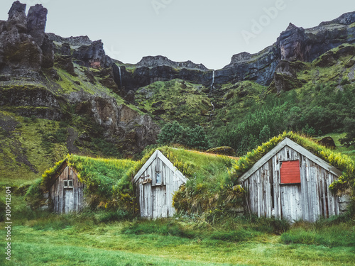 Row of grass covered wooden houses in Nupstadur in Iceland with moody weather
