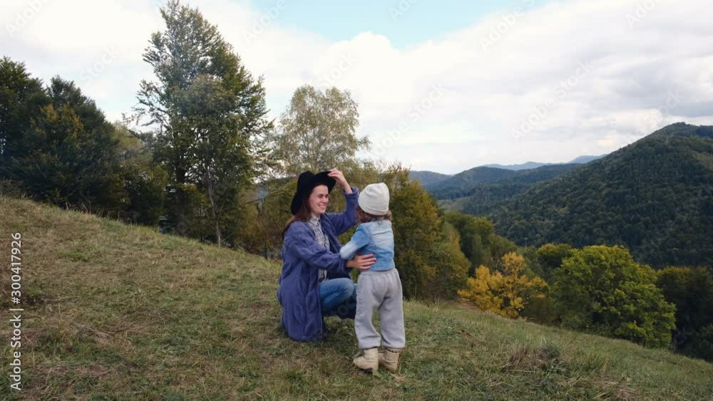 Cheerful pretty daughter smiling with her mother, spending time together with overlook amazing of mountains landscape, beautiful and inspiring camp location. Young woman playing with her child. Cheerful pretty daughter smiling with her mother, spending time together with overlook amazing of mountains landscape, beautiful and inspiring camp location. Young woman playing with her child.