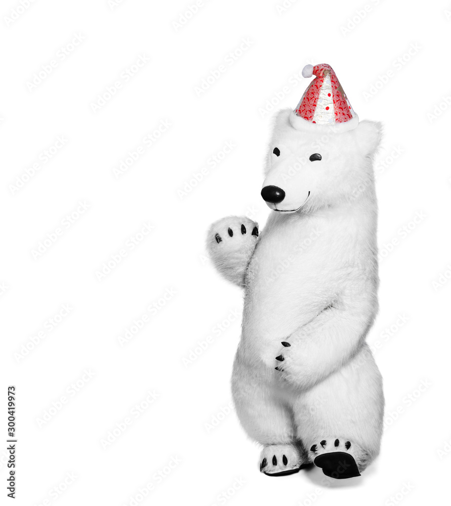 Fototapeta premium Polar bear toy in red cap waving his hand in greeting. Polar bear isolated on white background