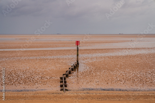 A groyne and grey clouds over the River Humber, seen from Cleethorpes, North East Lincolnshire, England, UK photo