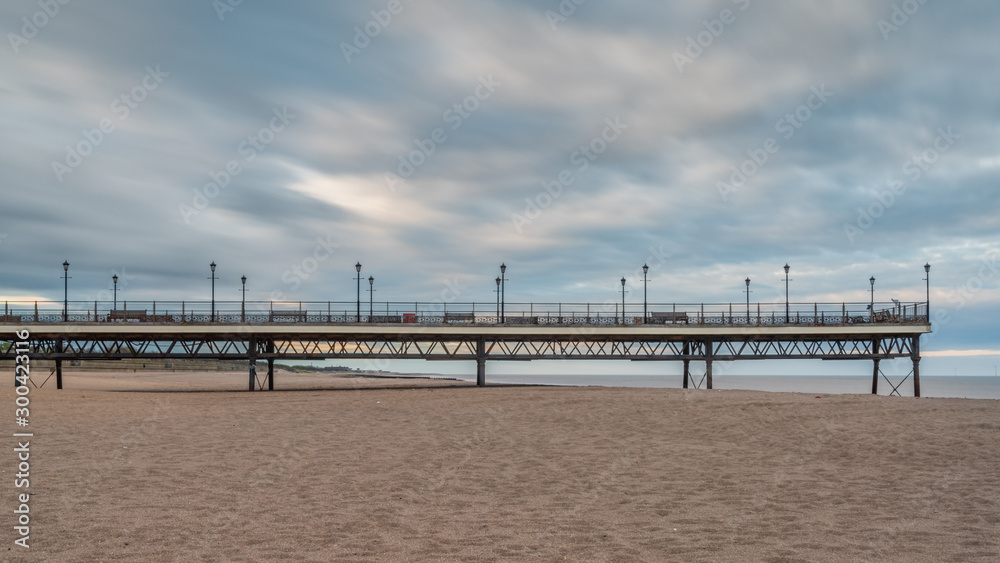 Naklejka premium Clouds over the beach and pier in Skegness, Lincolnshire, England, UK