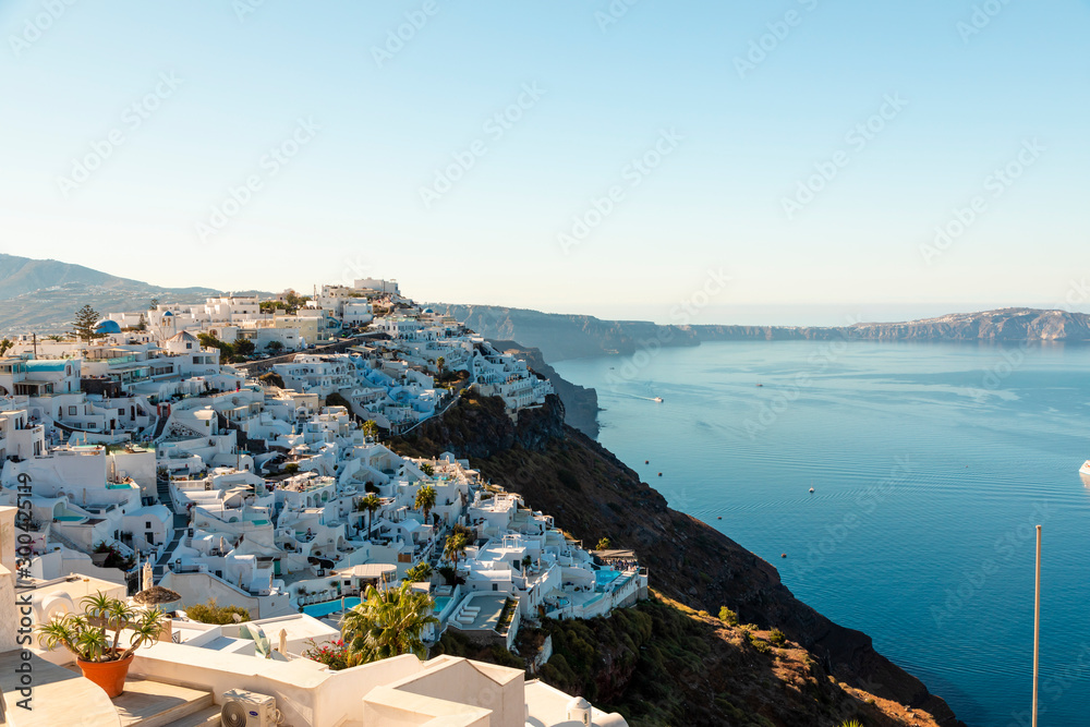 Small villages of white buildings with the ocean in the background on Santorini Island in Greece.