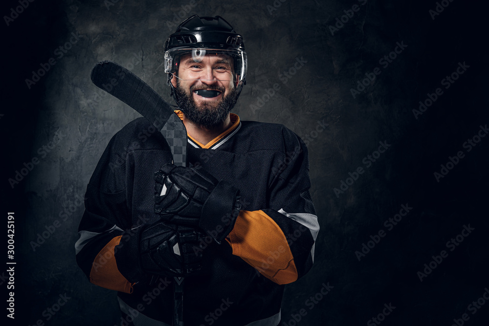Happy toothless hockey player is posing for photographer with hockey stick. Happy toothless hockey player is posing for photographer with hockey stick.