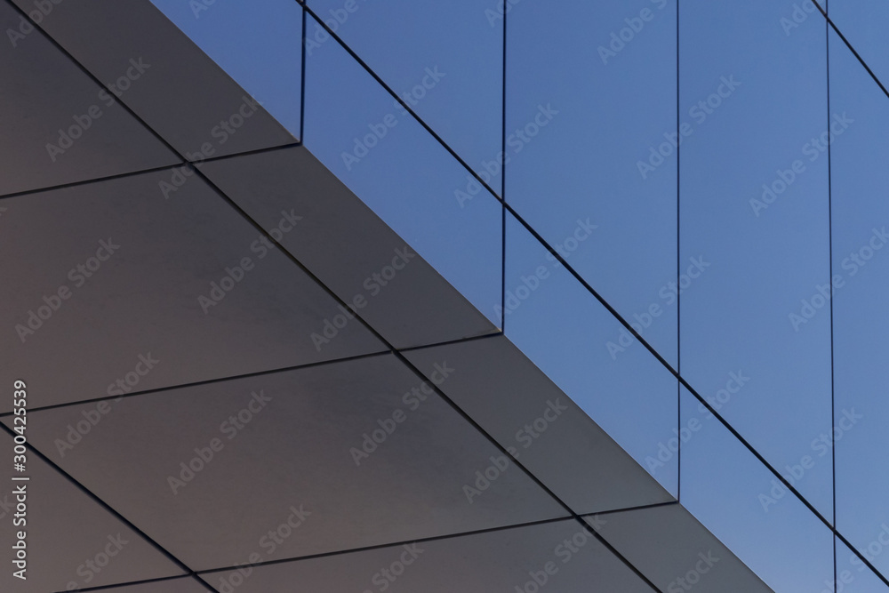 Geometric colored building facade elements with planes, lines and corners with light flare and reflections for an abstract background and texture of white, blue, gray colors. Place for text Geometric colored building facade elements with planes, lines and corners with light flare and reflections for an abstract background and texture of white, blue, gray colors. Place for text