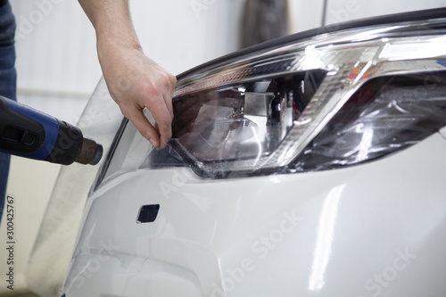 Installation of protective film for car paint.Professional installation of protective film on the car body. © Александр Поташев