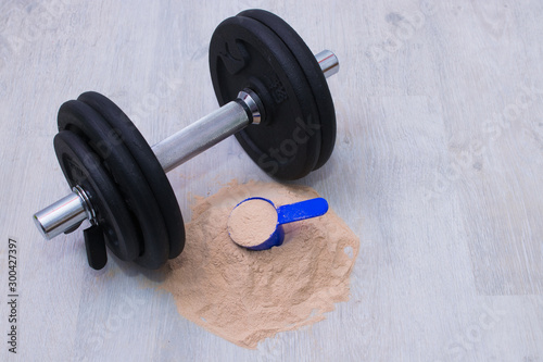 protein powder and dumbbell in the gym
