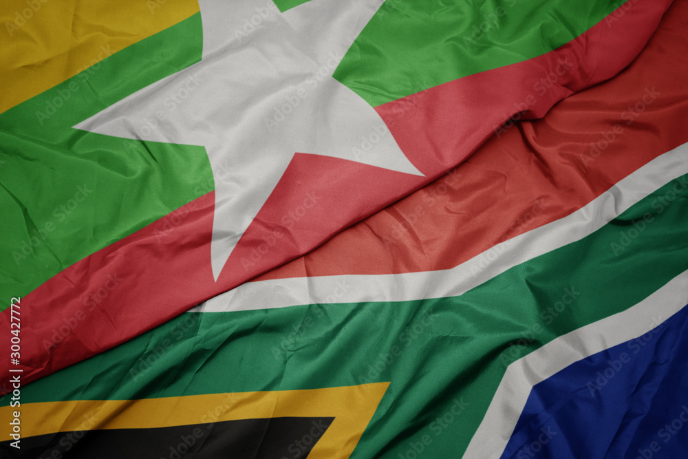 waving colorful flag of south africa and national flag of myanmar.