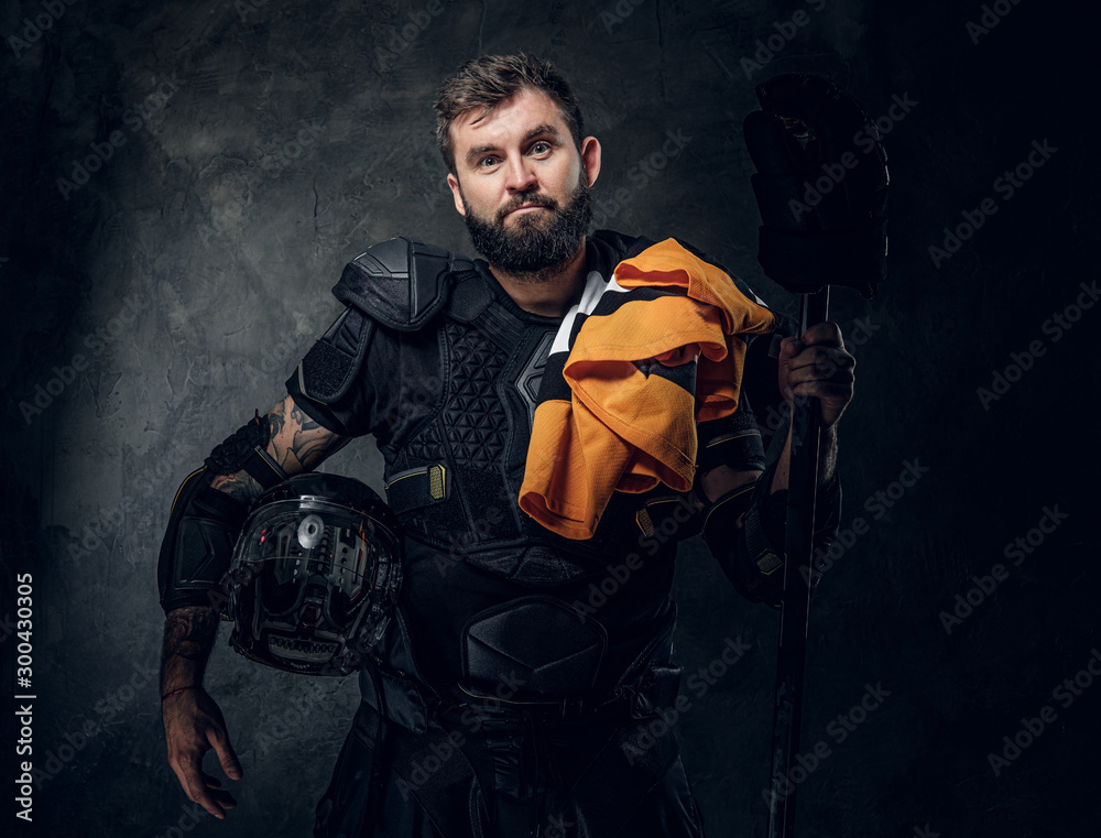 Φωτογραφία Portrait of serious bearded hockey player with his sport gear in hands