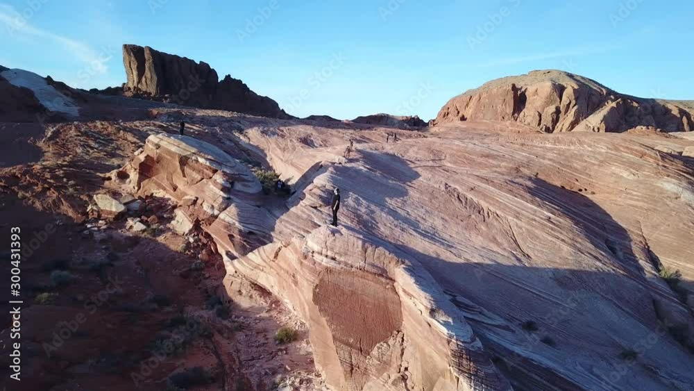 Hiker Standing on Fire Wave Rock Formation in Valley of Fire State Park Nevada Usa, Orbit Aerial Hiker Standing on Fire Wave Rock Formation in Valley of Fire State Park Nevada Usa, Orbit Aerial