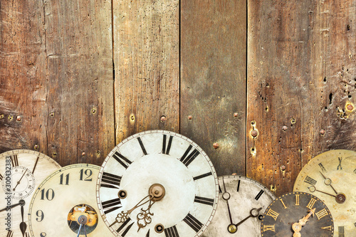 Vintage clocks in front of an old weathered wooden wall