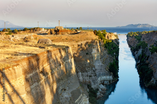 Coastal fortifications of the Corinth Canal in Greece in the bright rays of the morning rising sun. photo