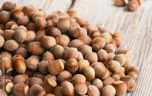 Natural organic hazelnut scattered on a wooden vintage background. Close-up. Healthy eating concept. Natural light. Food background, photo wallpaper.