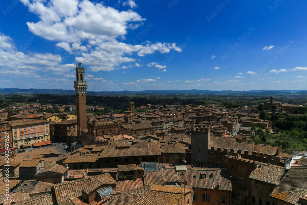 Siena town in Italy and Mangia Tower with the landscape in background 
