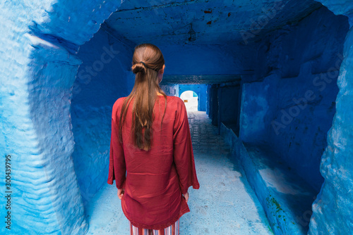 tunnel in the blue city of morocco. tourist stands with her back to the camera © nelen.ru