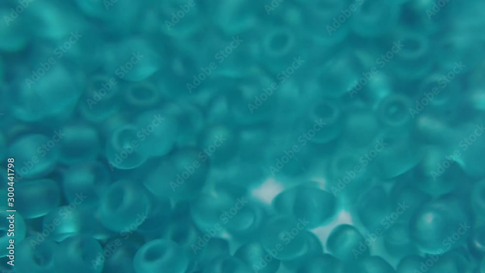 Pouring green jewelry beads into a white plate. Pouring green jewelry beads into a white plate.