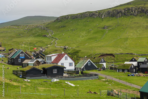 Beautiful village of Mykines with colorful houses with grass on the roofs, Mykines island, Faroe Islands, Europe.