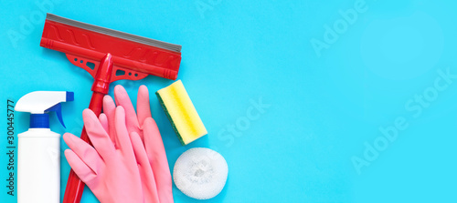 Cleaning and cleaning accessories, Gloves, spray, sponges, scraper for windows on a blue background. Cleaning Service Concept. Flat lay, Top view.