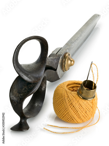 Ancient, professional scissors of the cutter, hank of yellow threads, thimble and needle