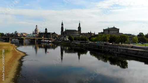 Aerial flying over River Elbe, view of the city center of Dresden, Germany. Famous Baroque-style architecture buildings are reflected in the water. Aerial shot taken by drone