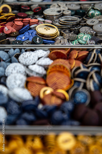 variety of different buttons in boxes with blurry foreground