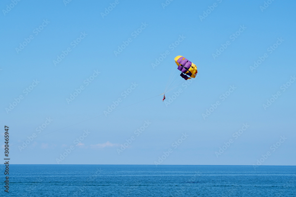 Skydiver on colorful parachute in blue sky. Active lifestyle, extreme sport, summer holidays, travel, vacation concept, copy space. Skydiver on colorful parachute in blue sky. Active lifestyle, extreme sport, summer holidays, travel, vacation concept, copy space.
