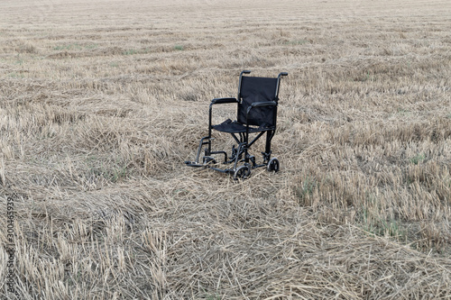 Empty wheelchair in a wide meadow. disabled carriage in nature. medical equipment for invalid