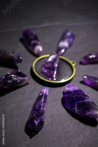 Top view on purple amethysts and necklace on dark background