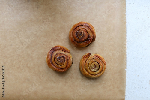 Homemade cinnamon rolls on a parchment paper. Top view.