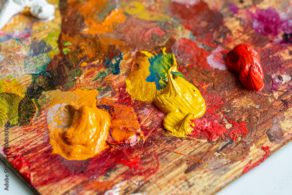 Orange, yellow and red oil paints on the artist's palette