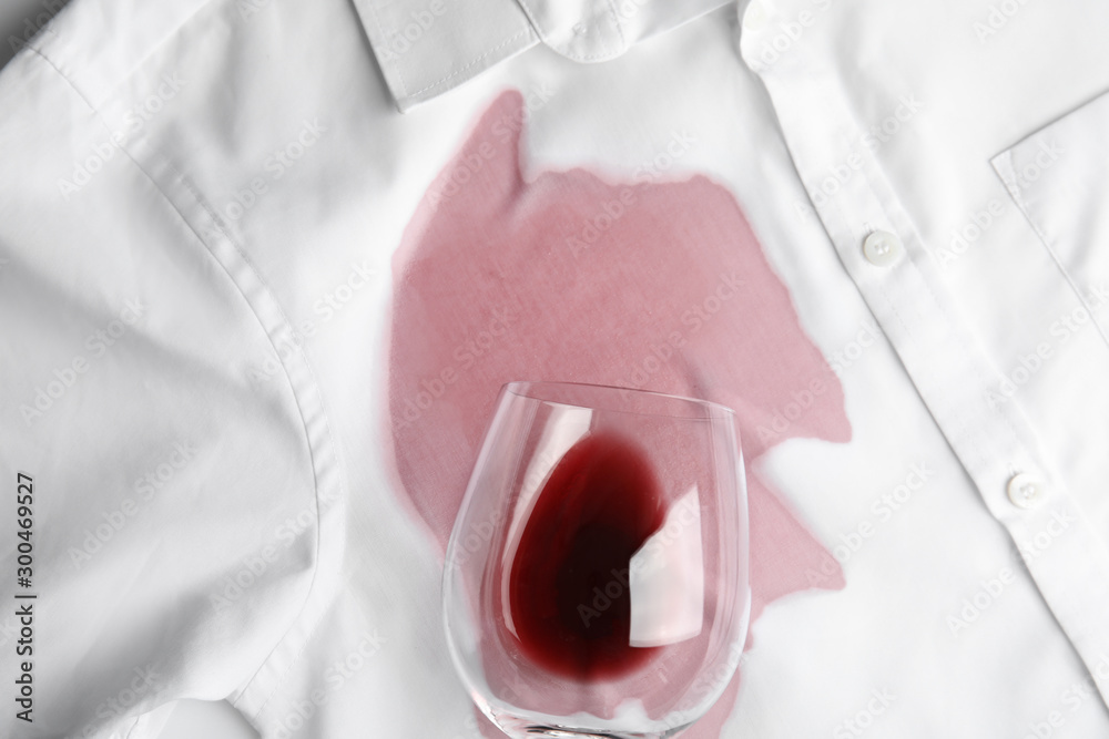 Overturned glass and spilled exquisite red wine on white shirt, top view - obrazy, fototapety, plakaty 