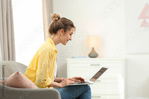 Young woman using modern laptop at home