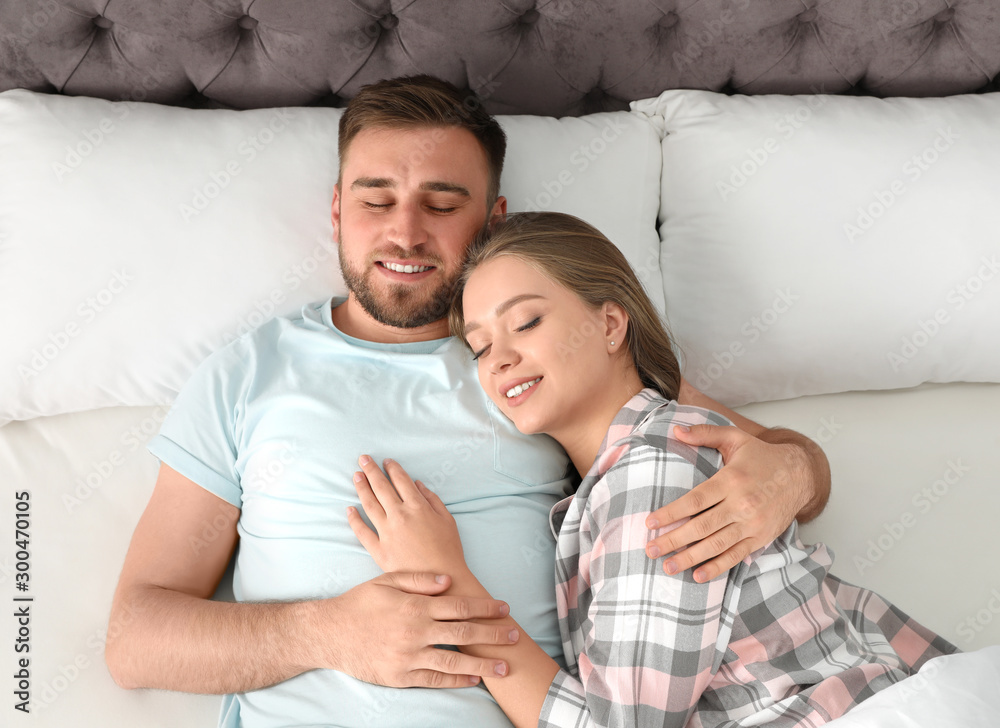 Young couple sleeping together in bed at home, top view Young couple sleeping together in bed at home, top view