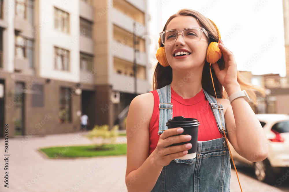Φωτογραφία Beautiful young woman listening to music with headphones on sunny day outdoors,