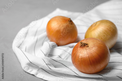 Fabric with ripe onions on grey table  space for text