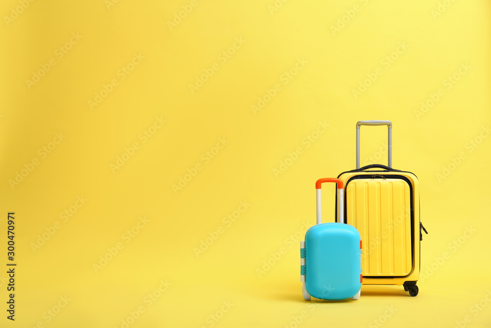 Stylish suitcases on yellow background, space for text - obrazy, fototapety, plakaty 