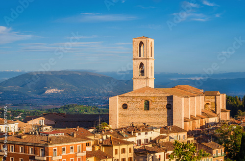 View Perugia huge and iconic St Dominic Basilica and Umbria countryside with the famous medieval city of Assisi in the background at sunset