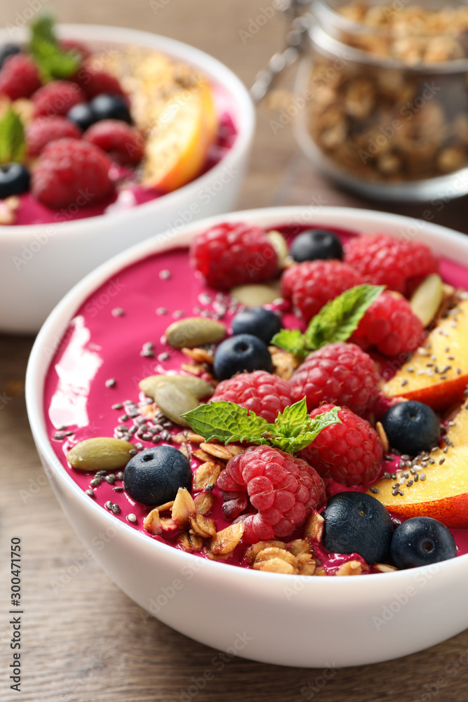 Delicious acai smoothie with granola and berries on wooden table Delicious acai smoothie with granola and berries on wooden table