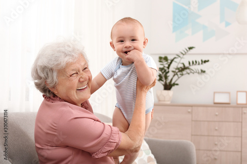 Obraz na plátne Happy grandmother with little baby at home
