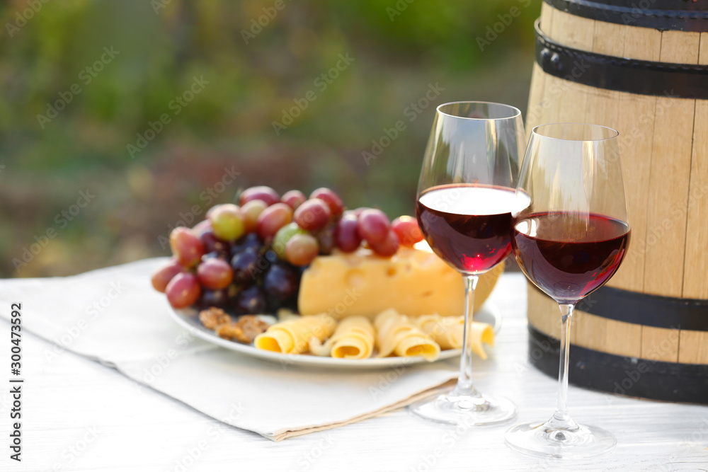 Composition with wine and snacks on white wooden table outdoors