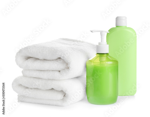 Folded soft towels and toiletries on white background