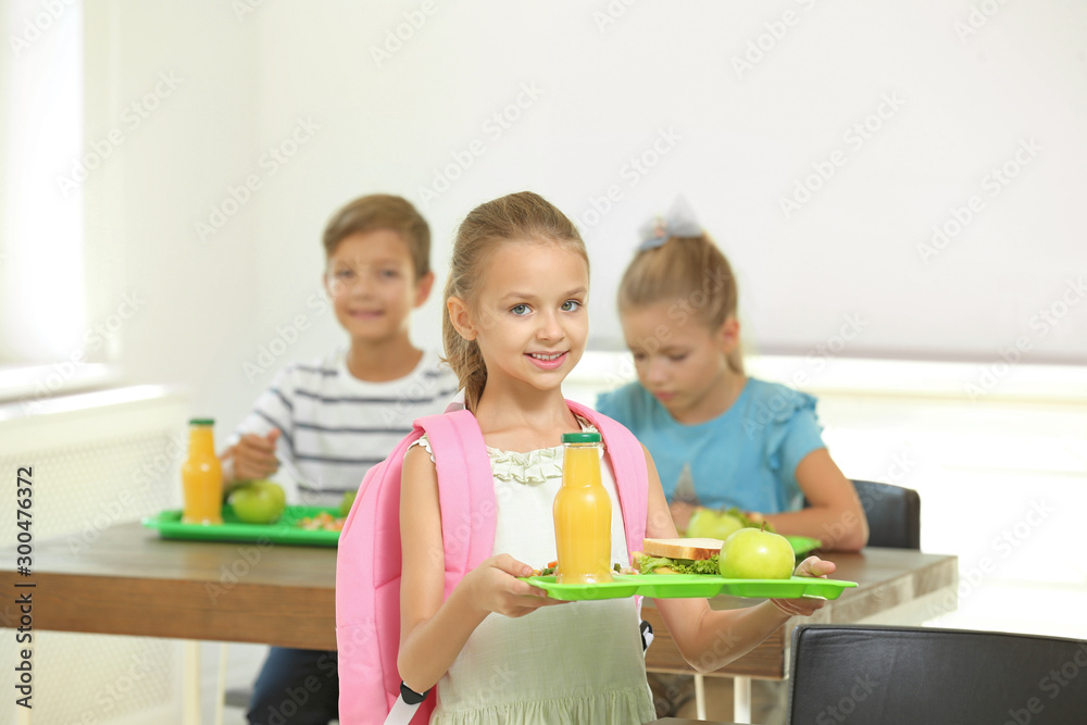 Happy children eating healthy food for lunch in school canteen Happy children eating healthy food for lunch in school canteen