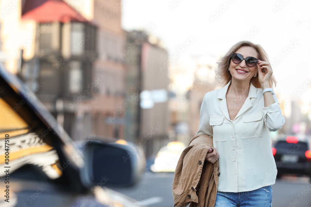Beautiful mature woman with sunglasses on city street