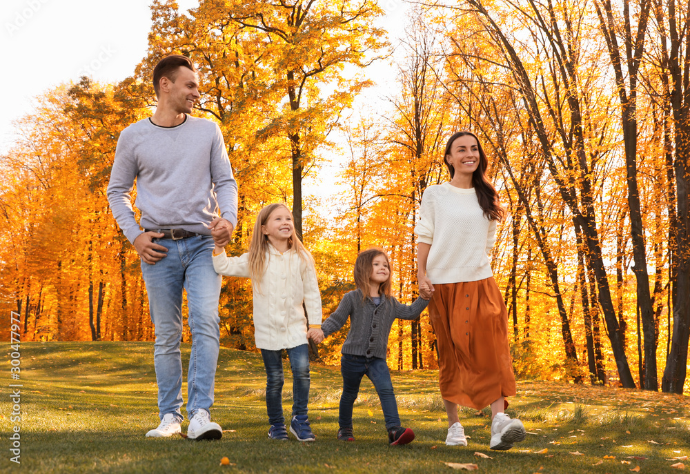Happy family with little daughters walking in autumn park Happy family with little daughters walking in autumn park